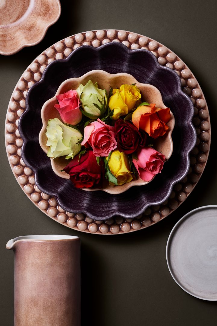 En av höstens inredningstrender 2022 är att skapa en extravagant dukning till middagsbjudningen. Här en dukning med Mateus-porslin i varma färger och med rosor. 