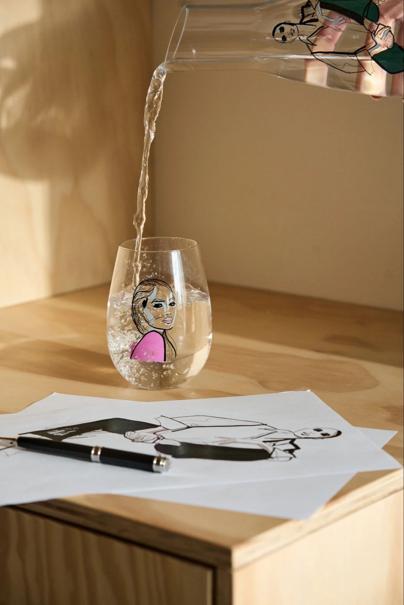 All about you vattenglas från Kosta Boda med rosa tryck och skiss av kvinnoansikte. 