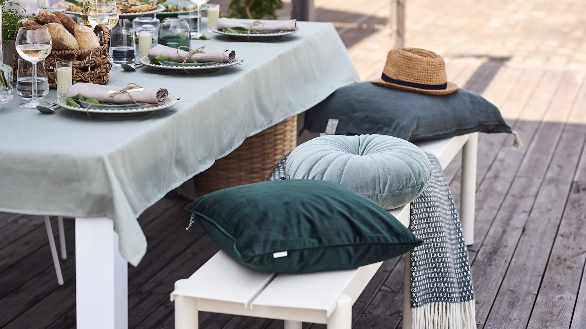 Bänken Linear från Muuto står bredvid bordet på trädgårdsfesten och skapar på så sätt plats för alla.