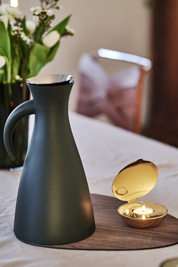 Grön Eva Solo kaffetermos & Shell ljuslykta från Design House Stockholm står framme på bordet. 