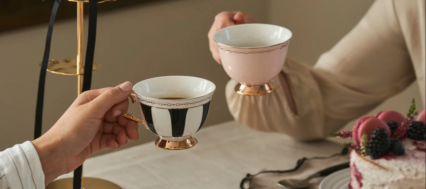 Fira Galentine's Day med en traditionell afternoon tea med dina väninor. Här ser du två väninor som höjer sina tekoppar i traditionellt formade tekoppar från Hilke.