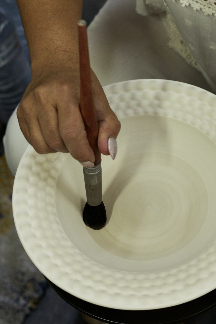 Mateus keramik målas för hand som är steg 6 i tillverkningsprocessen.