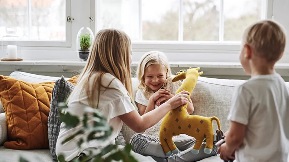Medan de vuxna lagar mat, leker barnen i soffan med gosedjur från OyOy.