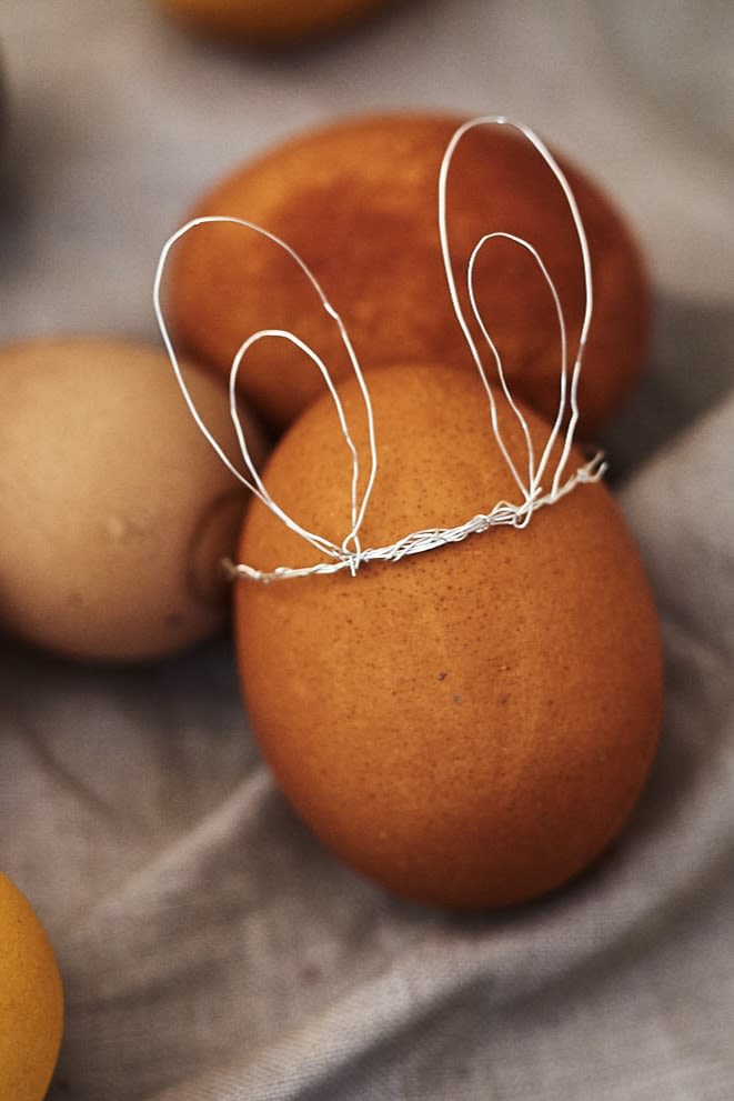 Ett enkelt påskpyssel att göra själv är dessa kaninöron i koppartråd att dekorera ägg med på en påskdukning.