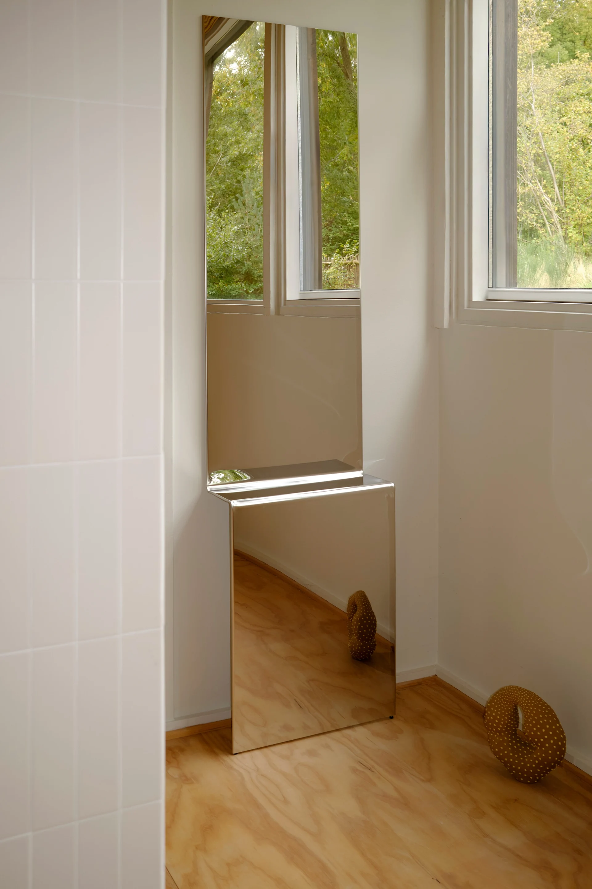 Hög staplad spegel i ett modernt rum. Pleat väggspegel från Muuto passar perfekt att dekorera vägg med. 