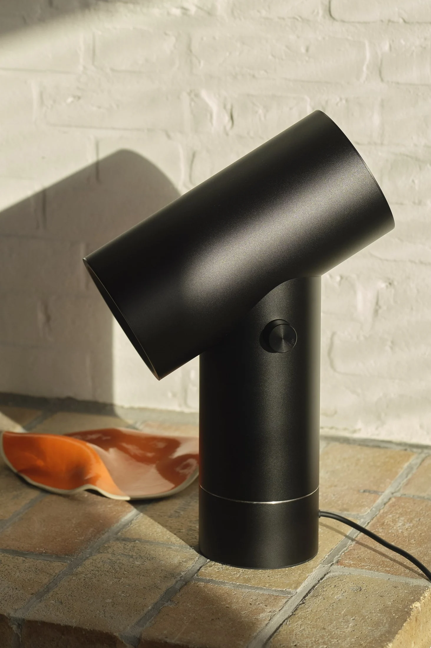 Den svarta bordslampan Beam från Muuto i en kaklad miljö.