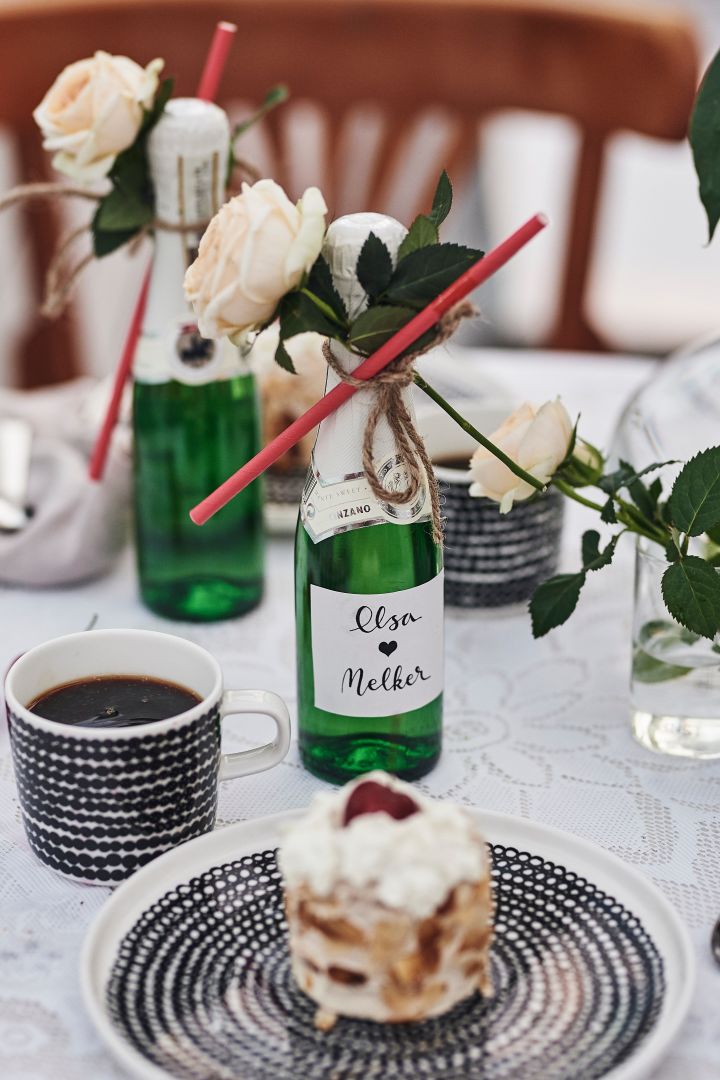Räsymatto-kaffekopp och assiett från Marimekko med grafiskt mönster används till den romantiska dukningen och bubbel serveras ur flaska. 