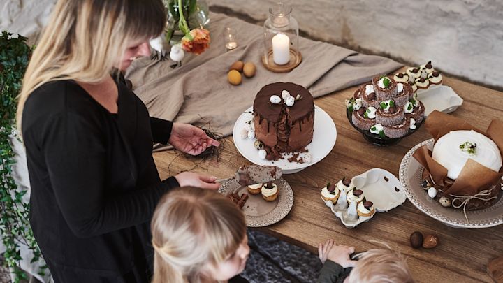 En rustik påskdukning med flera olika påskdesserter uppdukade som chokladtårta som gästerna skär en bit av. 