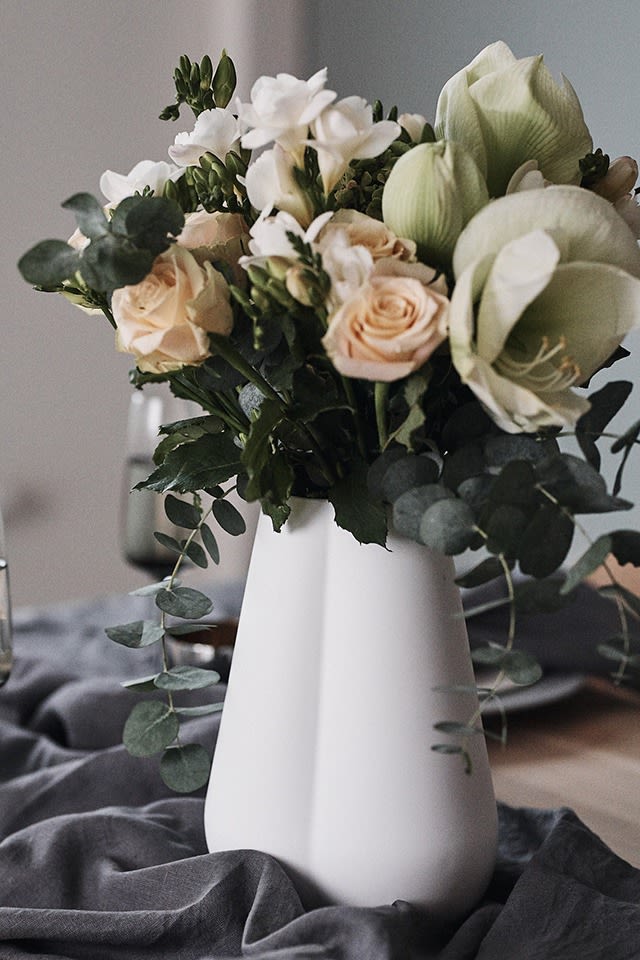 Nyårsfestens vackra bukett får husera i vit hög vas från Cooee Design som blir en festlig dekoration på bordet. 