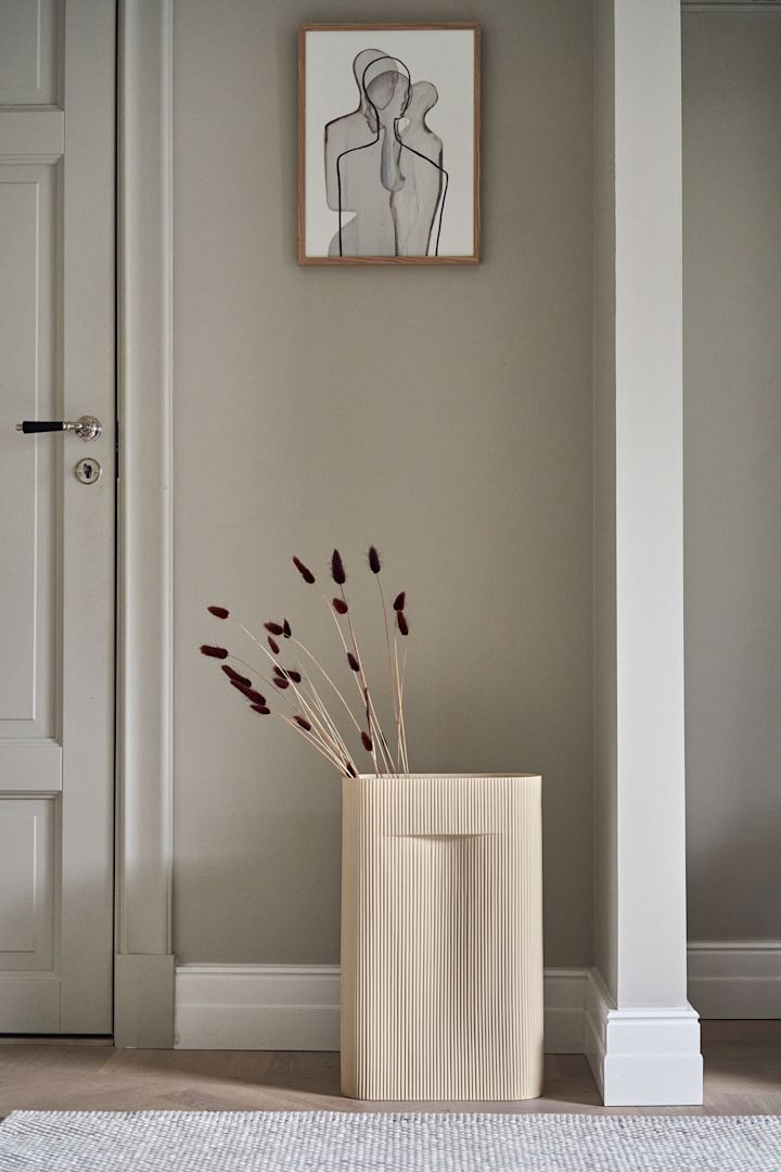 Stylingtips från Muuto - inred med denna stilrena Ridge vas i beige som är fylld med fina torkade blommor med Mother Poster från Paper Collective ovanför på väggen.