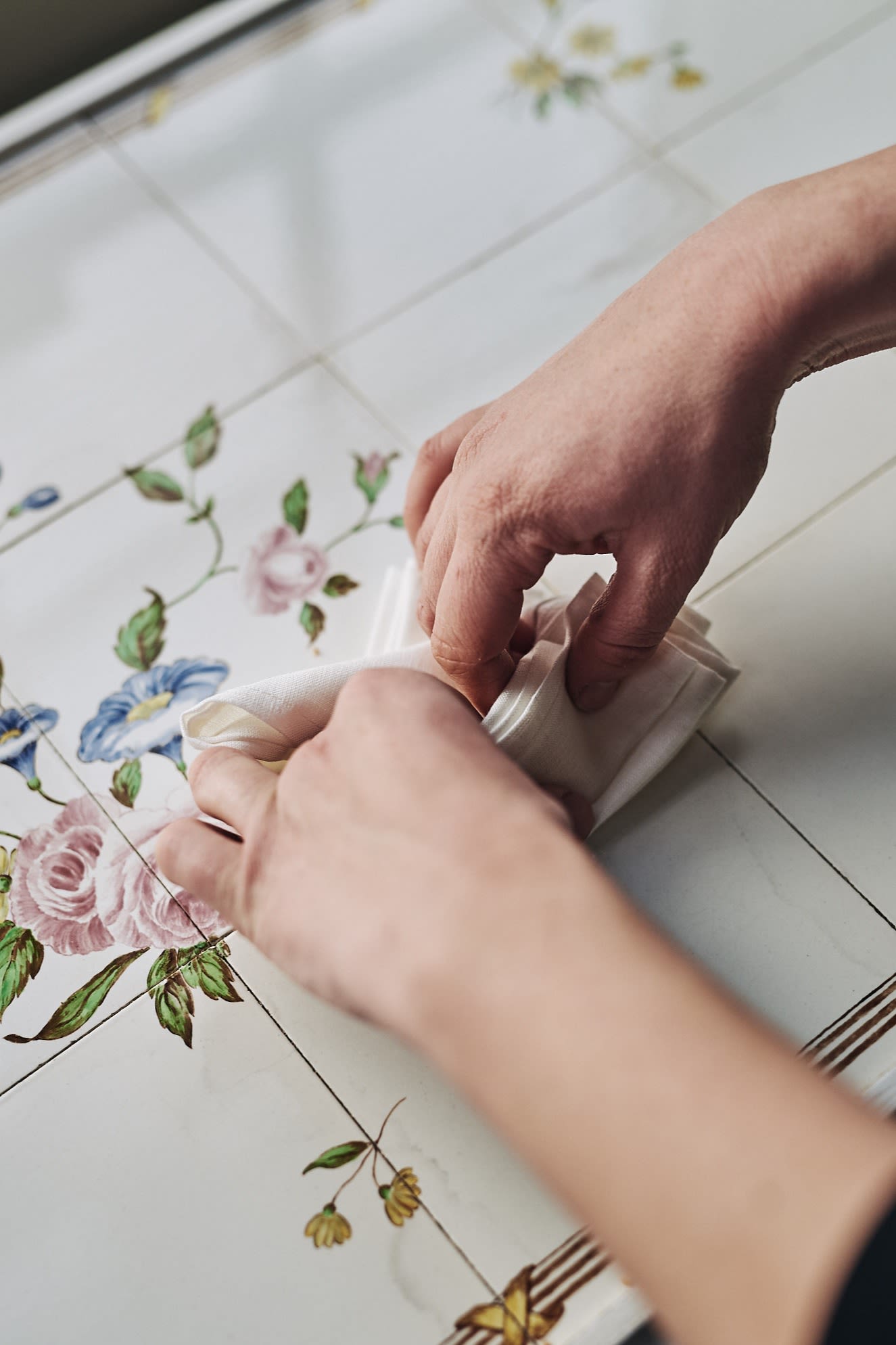 steg fyra och fem i servettvikning med vit servett till formen av en solfjäder.