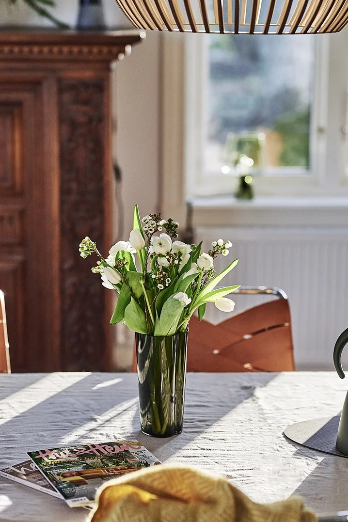 Krispig vårbukett huserar i Iittalas Alvar Aalto vas i grön färg och sprider stämning i den retroinspirerade matplatsen.