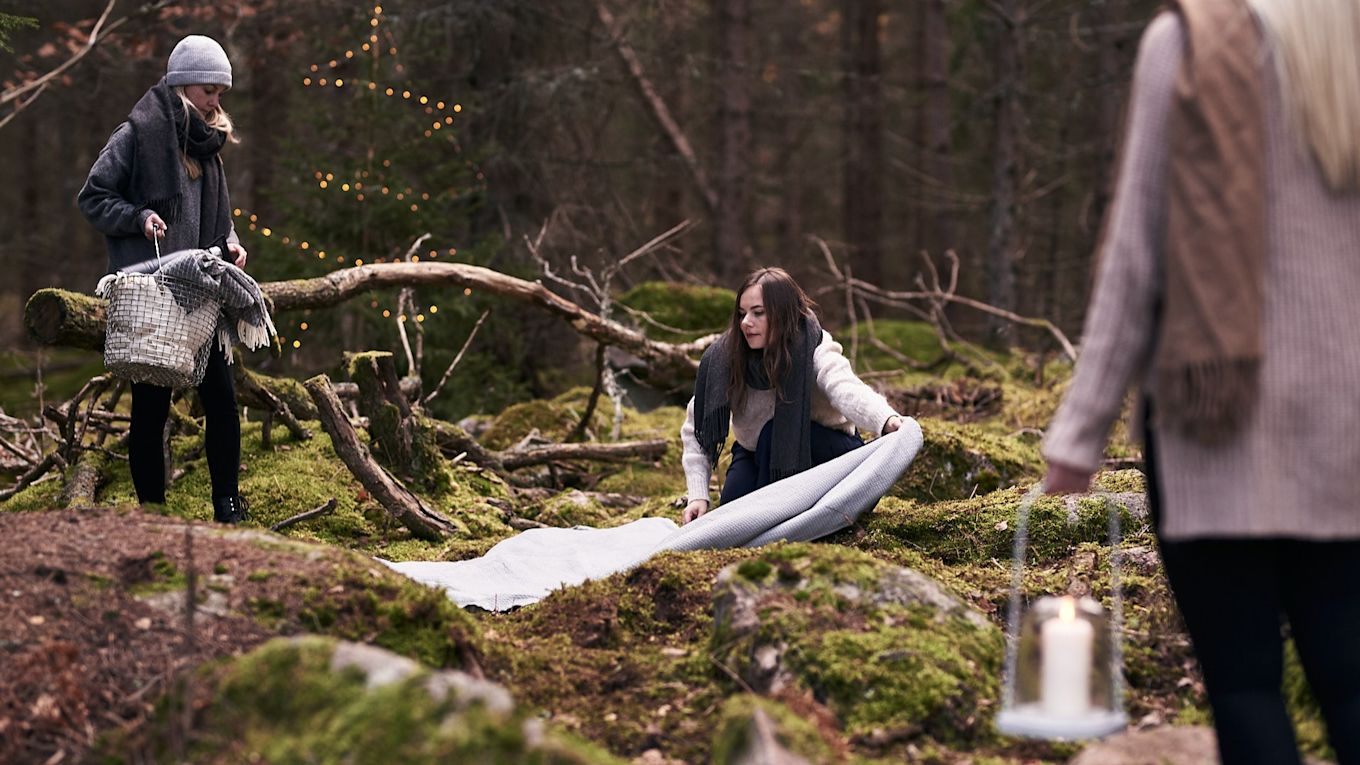 Glöggmingel i skogen förbereds med ett överkast från Nordic Nest på marken. 