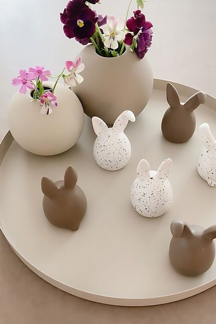 Triplets av påskharar i två färger från DBKD står på en bricka, bredvid två bollvaser från Cooee Design i @sachi_rooooms hem.