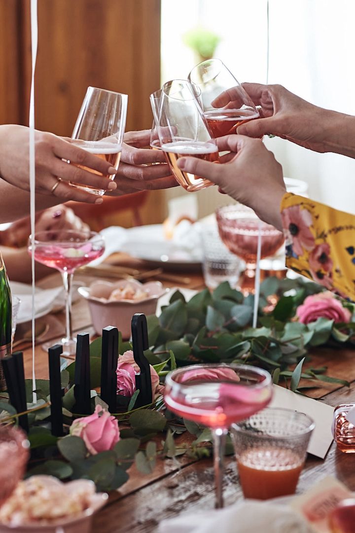 Vännerna på tjejfesten skålar med låga champagneglas från Riedel. 