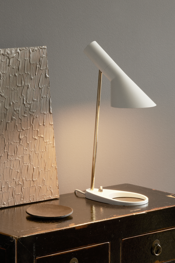 AJ-lampserien av Arne Jacobsen tillhör en av Louis Poulsens mest populära och ikoniska belysningsserier. I samband med varumärkets 150-årsjubileum lanseras en kollektion som går i vitt och ljusrosa. Här AJ bordslampa.