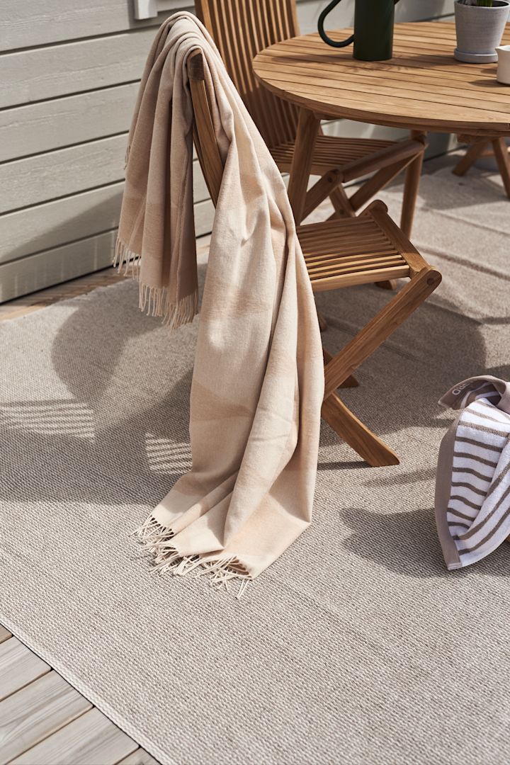 Balkonginspo med Mellow plastmatta från Scandi Living som är en perfekt balkongmatta då den klarar av väder och vind samt att den är enkel att rengöra, här en stor variant i enfärgat i nyansen greige, placerad under utemöbler i teak.