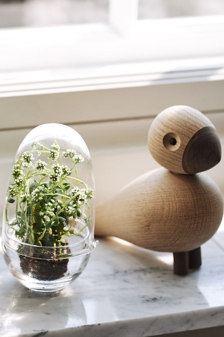 Grow odlingskupor från Design House Stockholm och Kay Bojesen fågel pryder fönsterbrädan i vardagsrummet som är inrett i skandinavisk stil. 