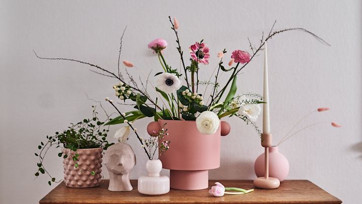 Ett stilleben med inredning i form av rosa krukor, vårblommor i arrangemang och skulptur från Cooee Design. 