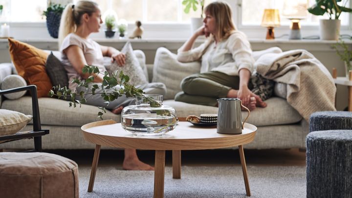 Ett vardagsrum inrett i skandinavisk stil och inredning med soffbord från Muuto, kuddar och sittpuffar från Design House Stockholm. 