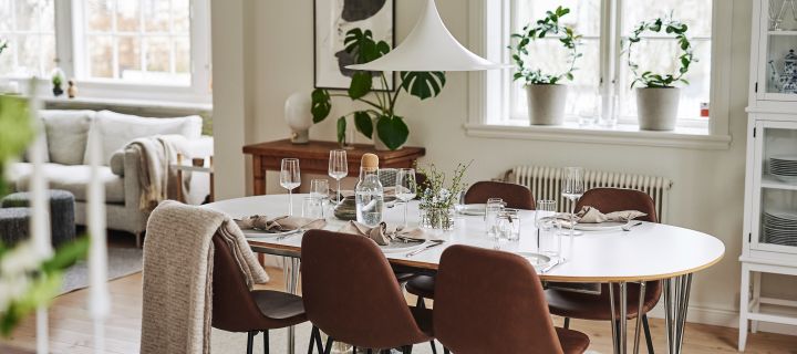 En matplats inredd i skandinavisk stil med inredning i svala toner och med matstolar i läder från House Doctor samt vit Semi lampa från Gubi i fokus.