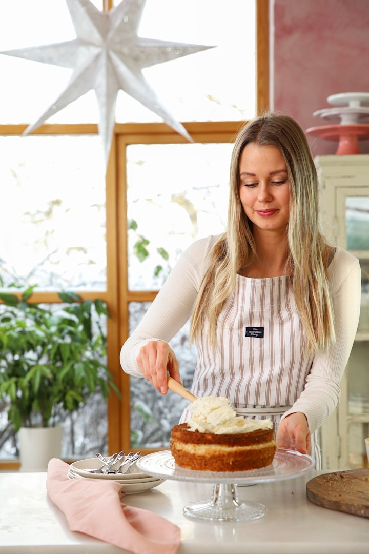 Baka med Frida - lär känna receptkreatören & ta del av hennes bästa bakningstips. Här sprider Frida Skattberg ut god grädde med Craft slickepott från Le Creuset på tårtan som står på Iittala Kastehelmi kakfat.