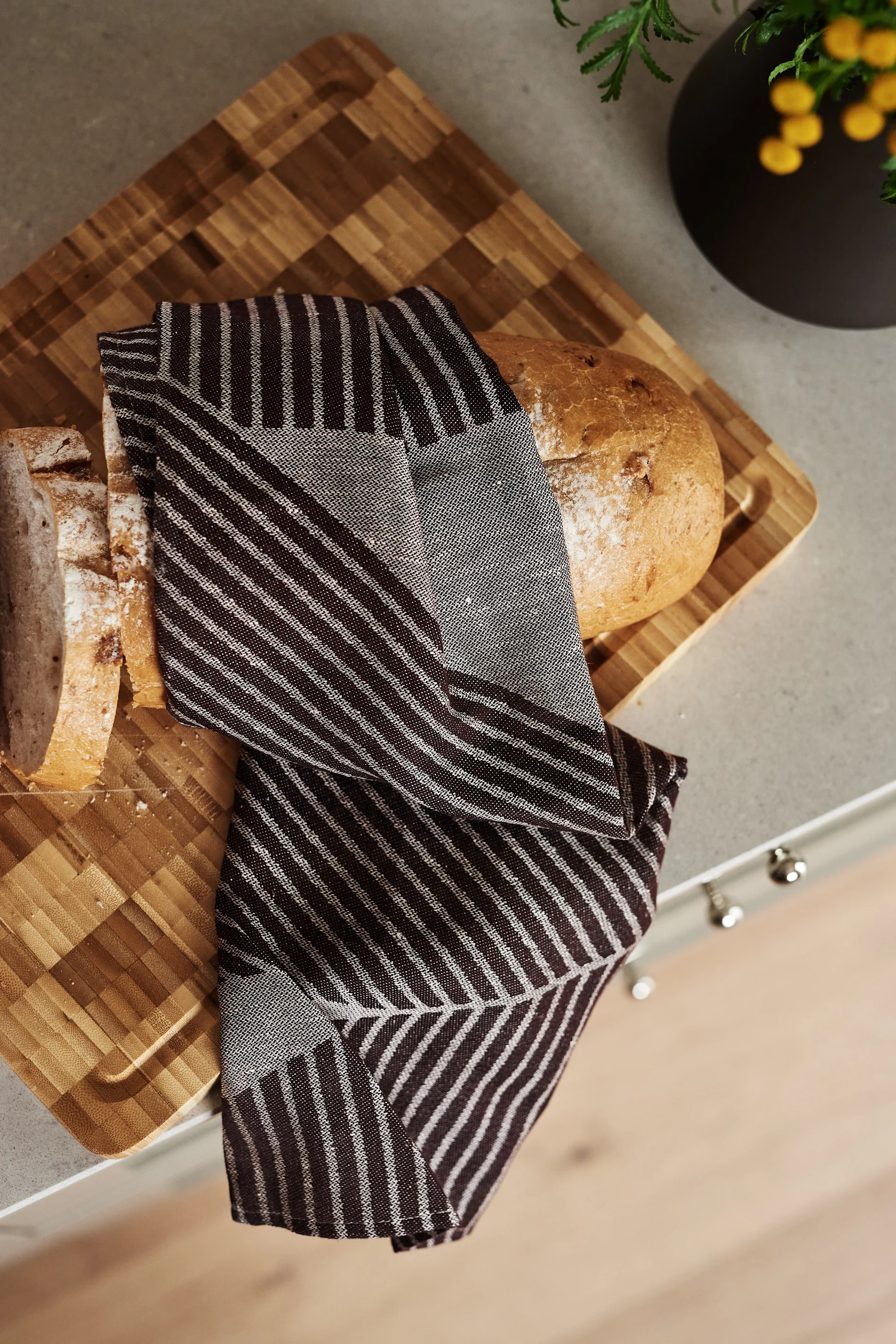 Förnya ditt kök med 11 praktiska & snygga kökstillbehör för enklare matlagning - här ser du stilrena Stripes kökshandduk från NJRD i brun och vit.