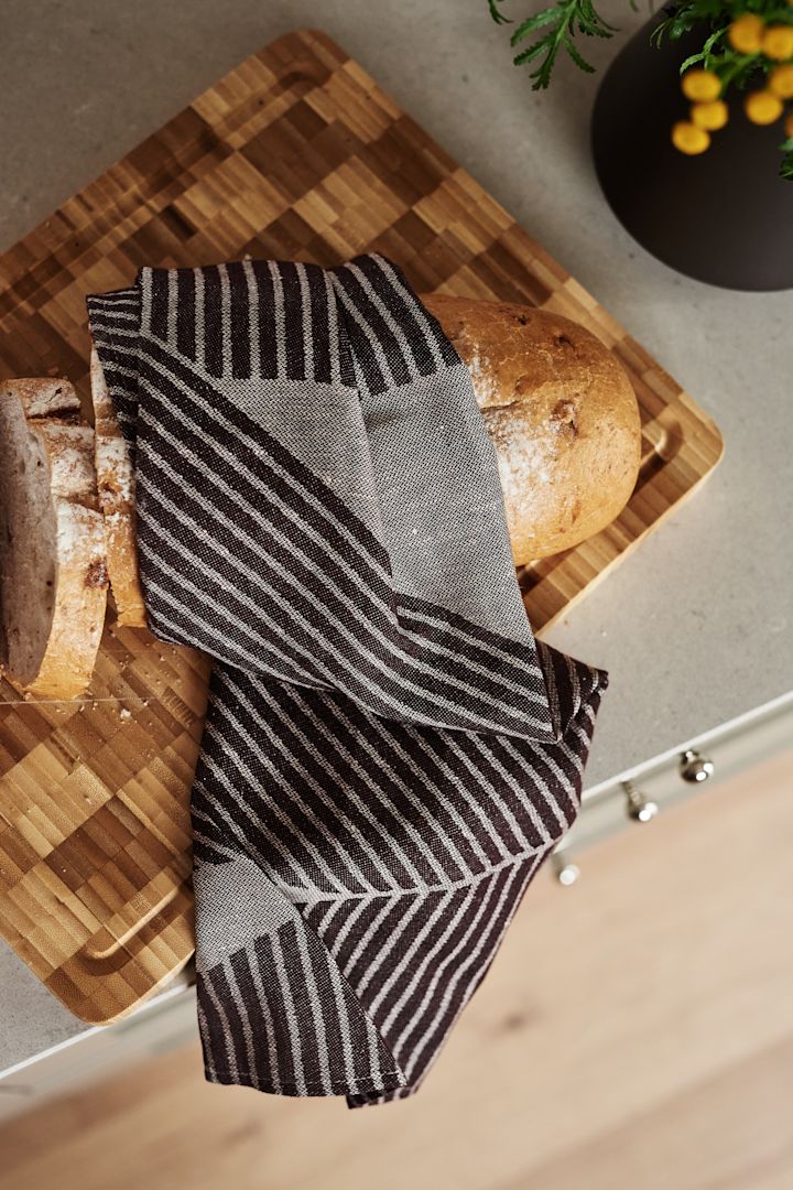 Förnya ditt kök med 11 praktiska & snygga kökstillbehör för enklare matlagning - här ser du stilrena Stripes kökshandduk från NJRD i brun och vit.