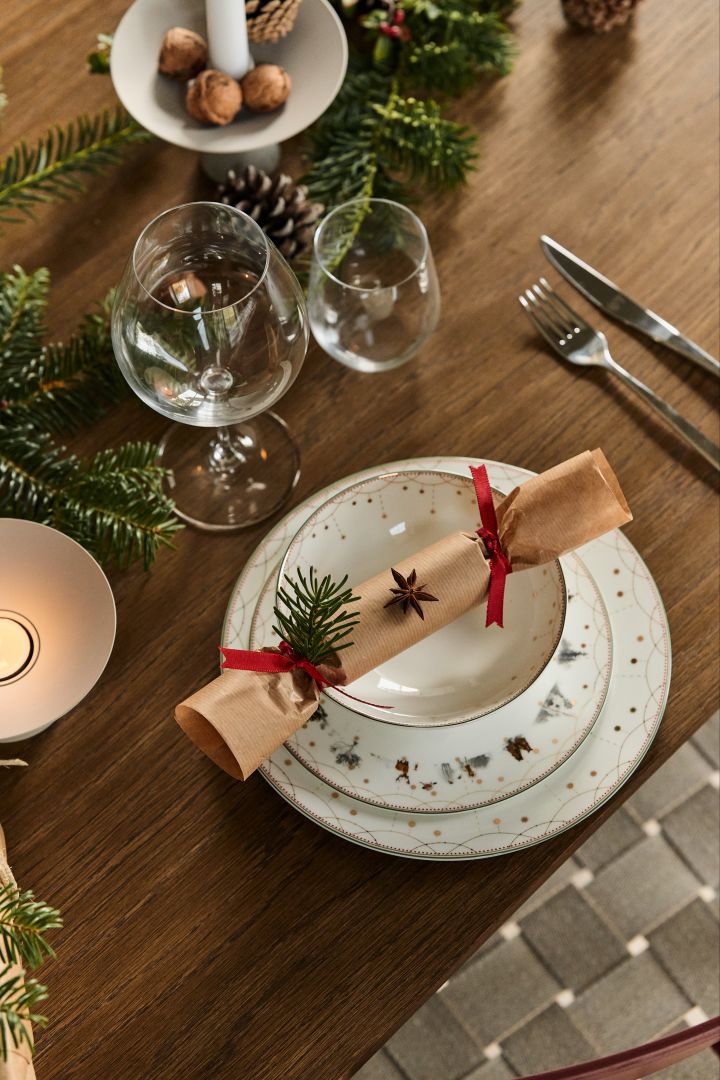 Pynta med granris dekoration på det dukade bordet tillsammans med Julemorgen porslin från Wik & Walsøe för att skapa julstämning vid middagen.