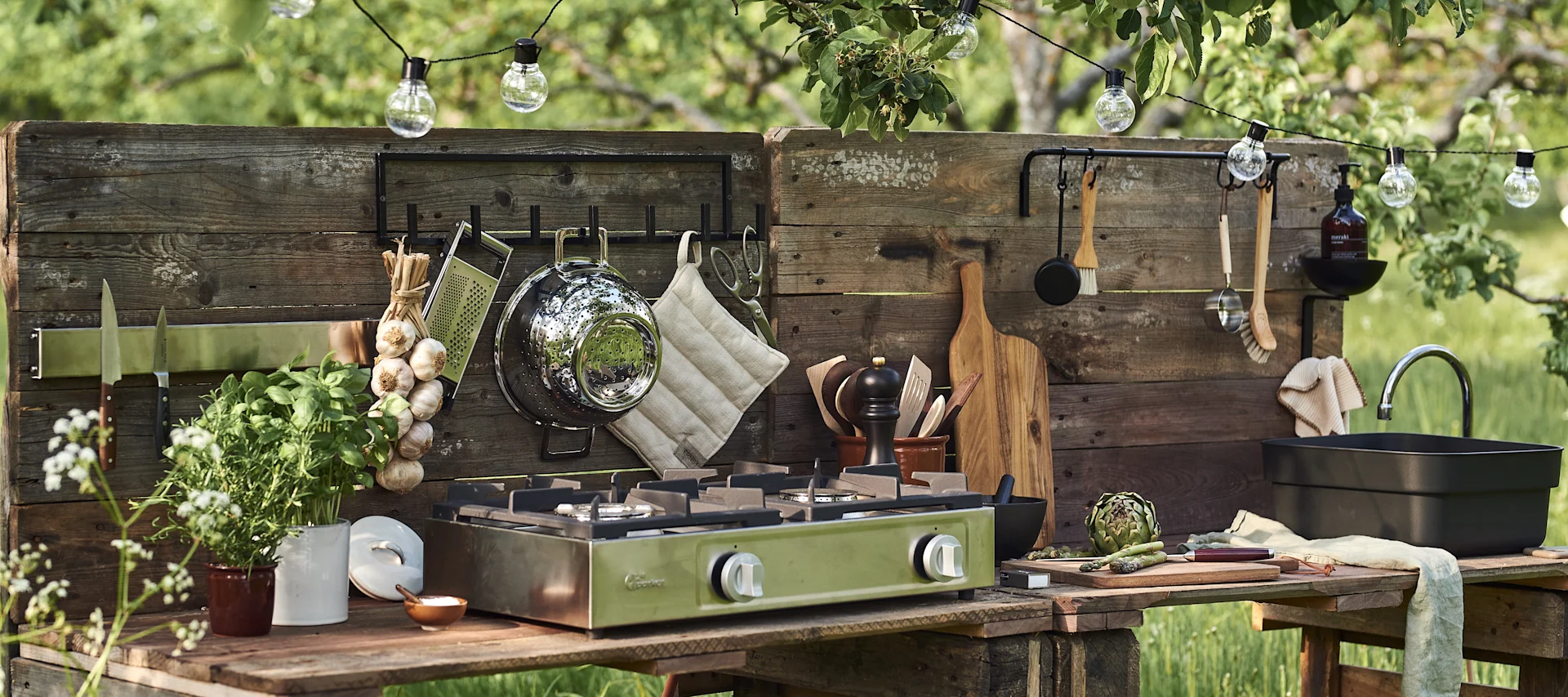 Inredaren Sara Zetterströms tips för att bygga utekök är att ha krokar och förvaring till dina köksredskap och inreda uteköket med en ljusslinga och diskbalja.