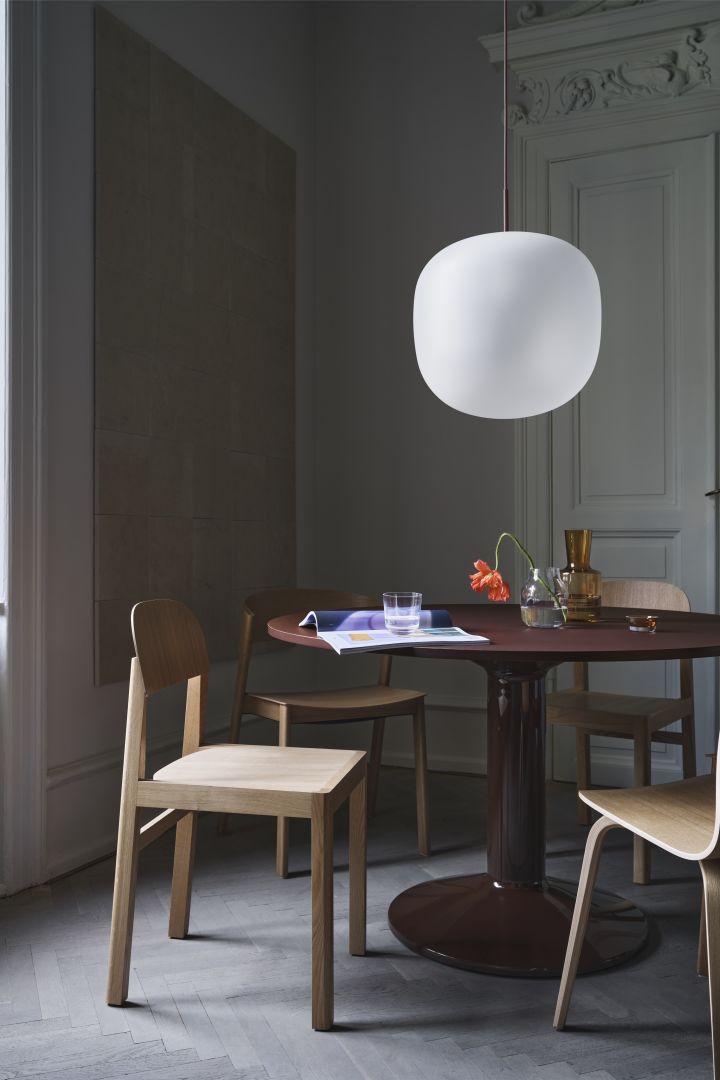 Cover chair är en av Thomas Bentzens mest berömda möbler, här i solid ek vid mörkrött, runt matbord.