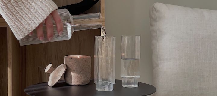 Inredning i räfflat glas är en av årets trender. Här fyller influencern @helenas.hem Ripple glas med vatten från ferm LIVING Ripple karaff.