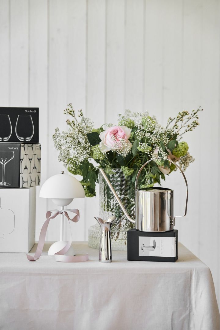 Bröllopstips, skapa ett presentbord där gäster kan lägga sina gåvor till er. Här ett romantiskt dekorerat bord med Flowerpot VP9 på bordet, vinglas, vattenkanna och vas. 