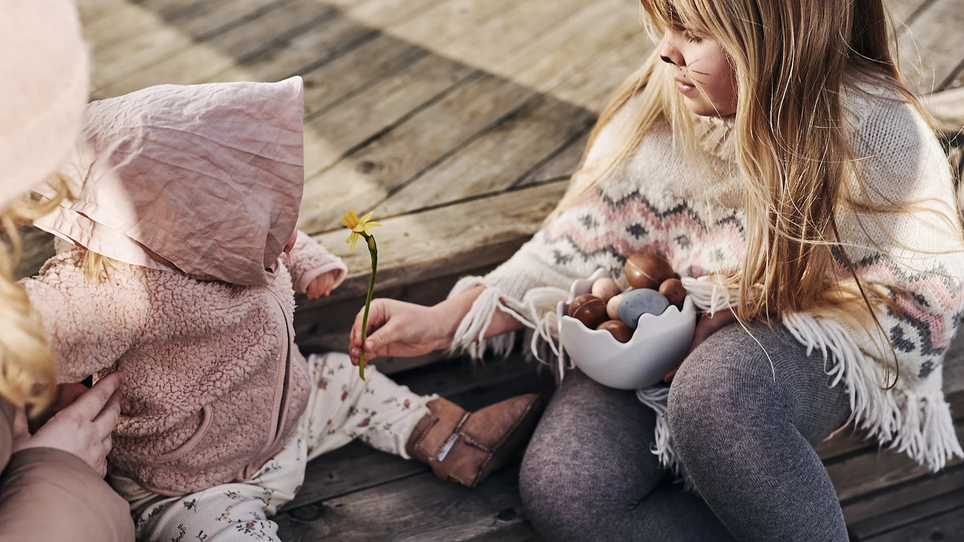 Barn utklädda till påskkärringar sitter på trappen och ska dela på påskgodiset som var vinsten i årets stora äggjakt. 