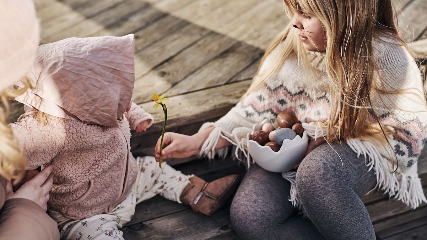 Barn utklädda till påskkärringar sitter på trappen och ska dela på påskgodiset som var vinsten i årets stora äggjakt. 