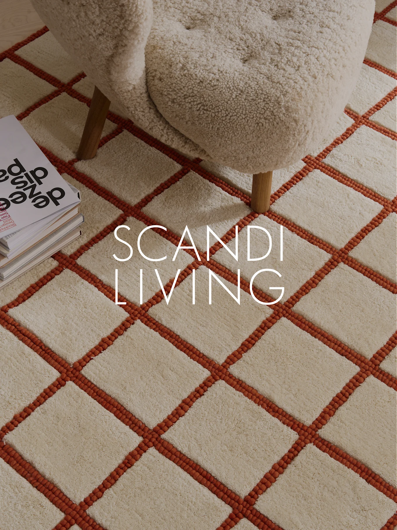 Gräddfärgad ryamatta med orange rutmönster, gräddfärgad fåtölj och böcker. Text: SCANDI LIVING.