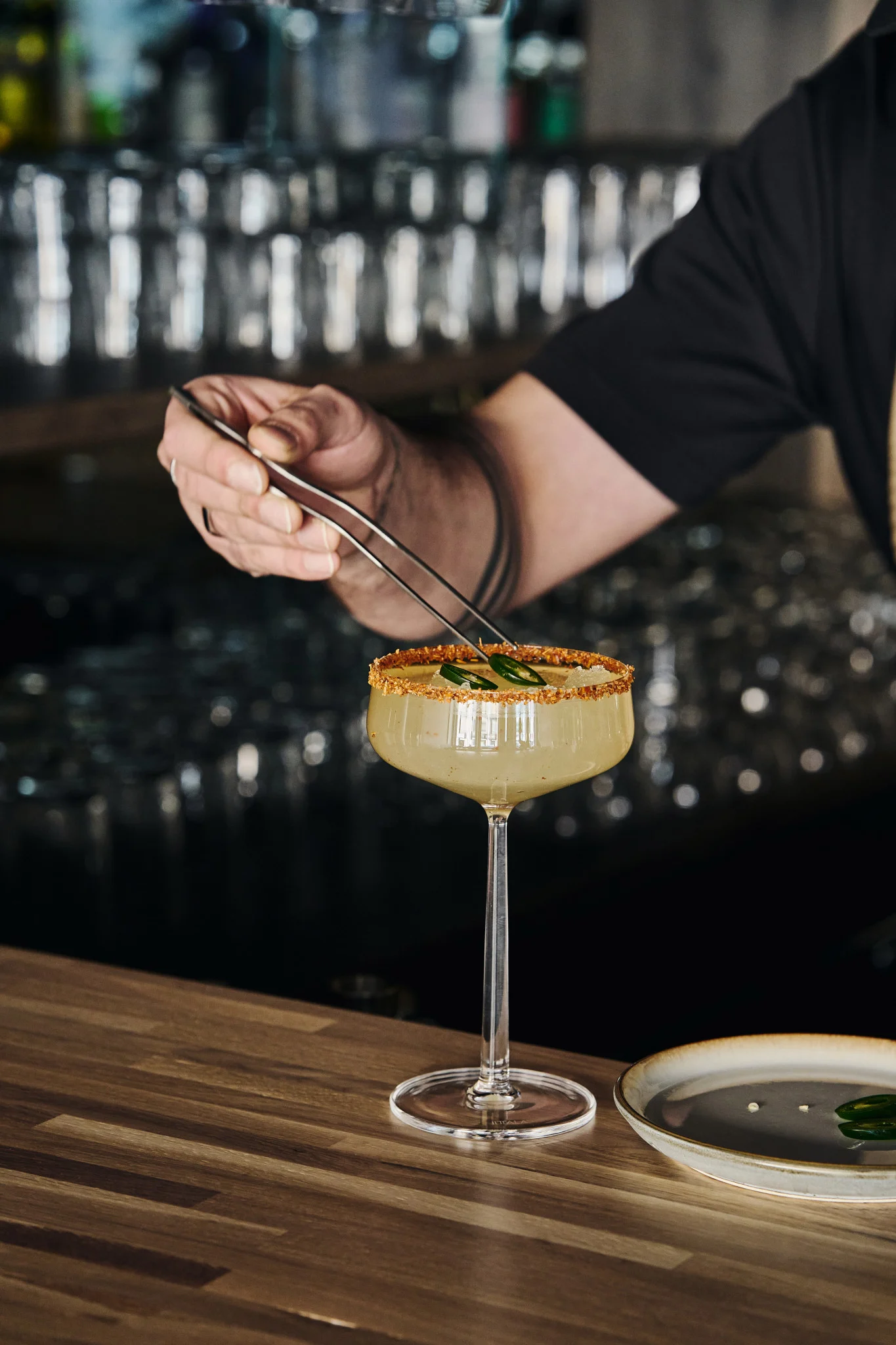 Perfekt för mocktails: cocktailglasen Essence från Iittala med drink, dekorerad kant och garnerade med jalapeñoskivor med hjälp av en tång.