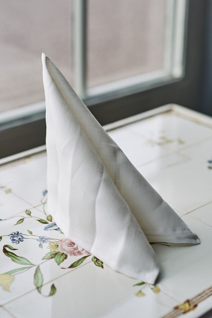 En klassisk och enkel servettvikning i form av ett segel med vit servett.