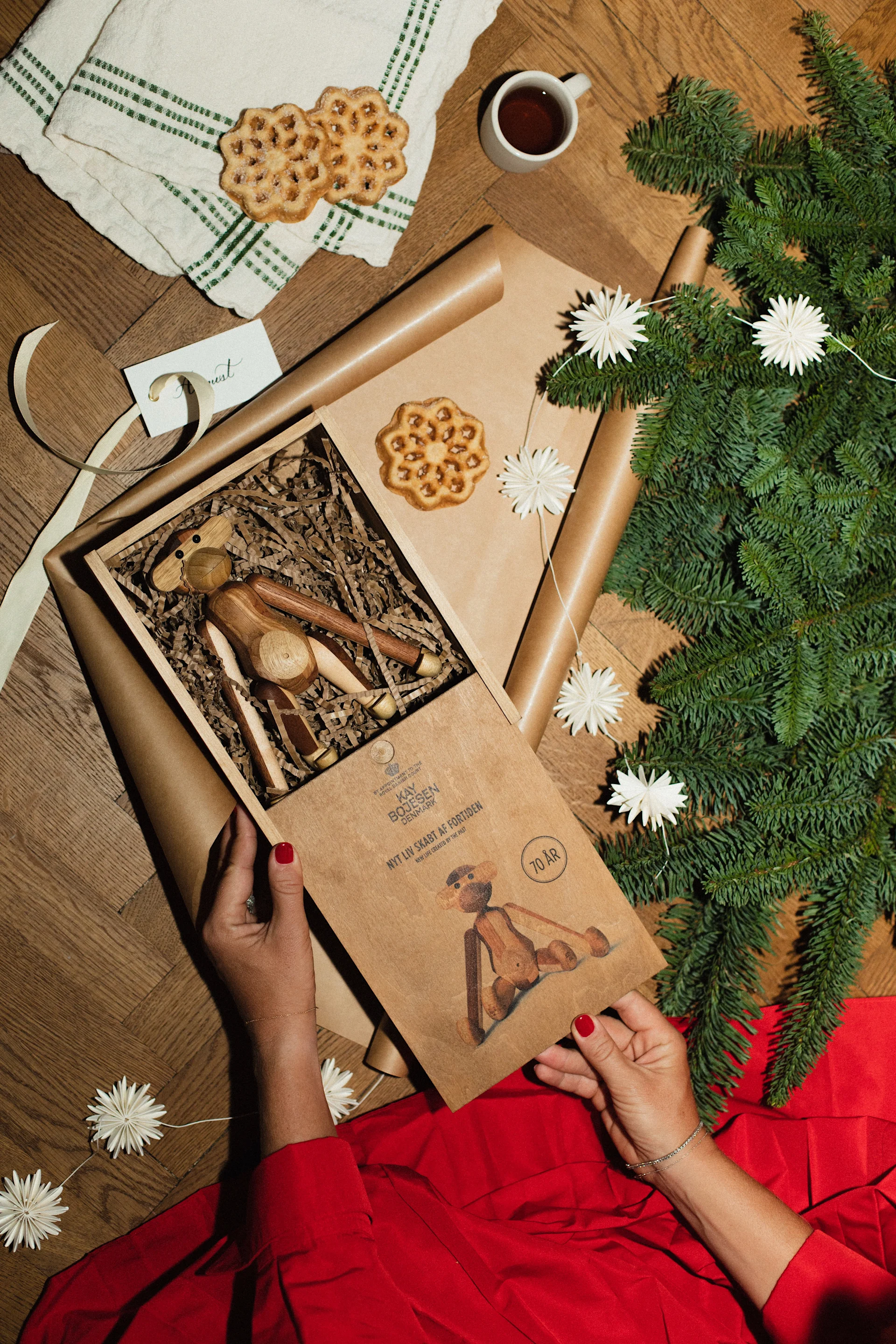 Ebba Kleberg von Sydow slår in en julklapp med Kay Bojesens apa klädd i en vacker klänning i rött.