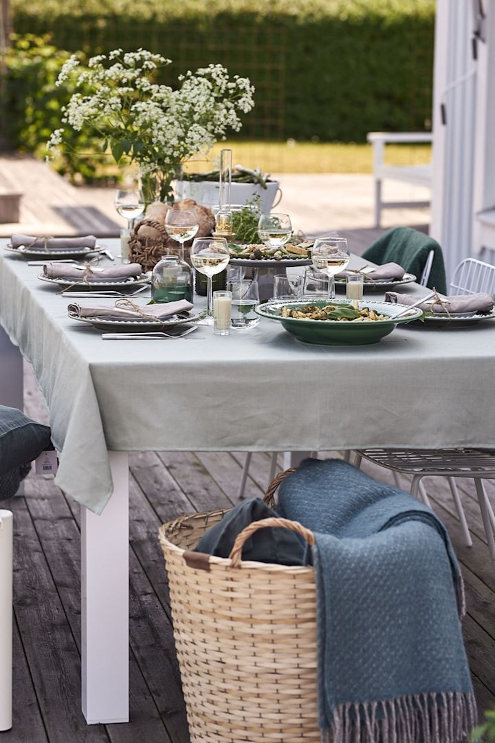 Det är uppdukat för trädgårdsfest med en grön linneduk som grund från Nordic Nest. 