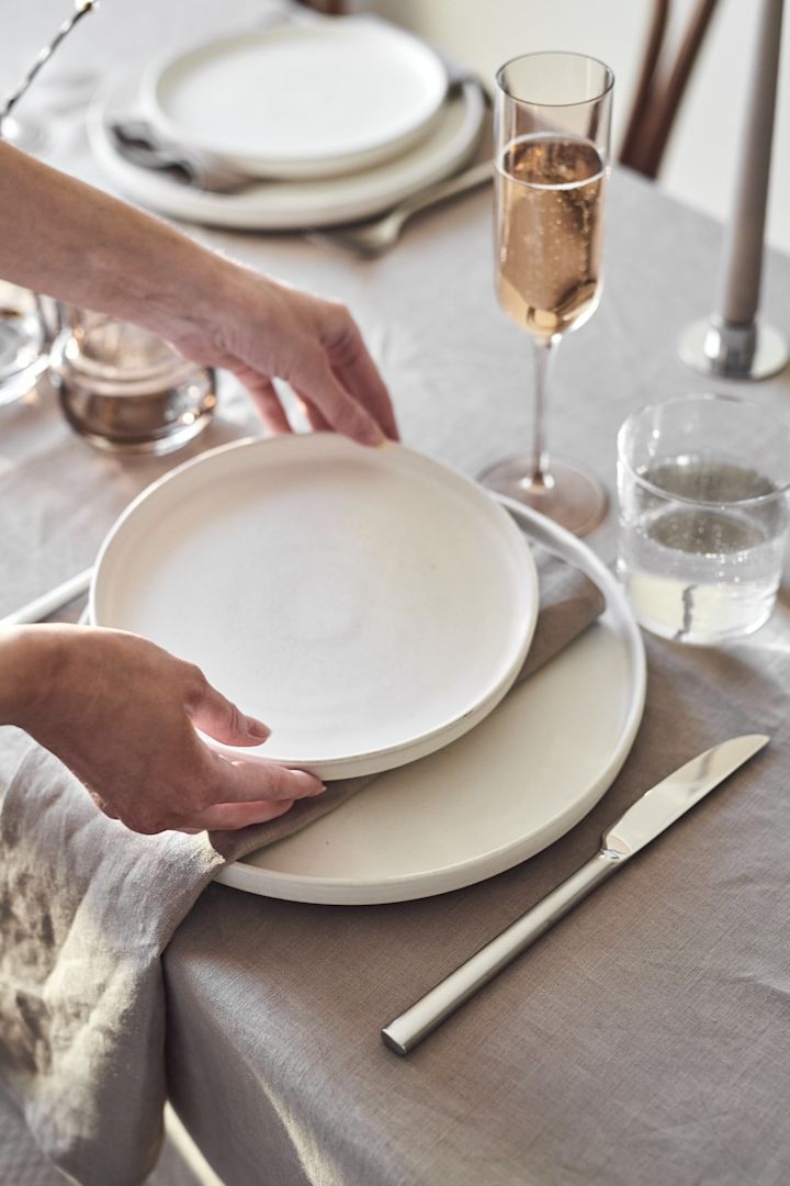 Genom att blanda blått och vitt porslin skapar du en mer dynamisk midsommardukning, här har den vita Swedish Grace Gala assiett kombinerats med Ostindia Floris tallrik. båda från Rörstrand.