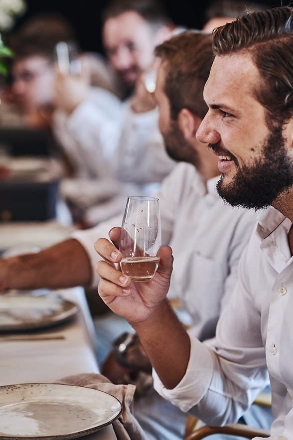En fördrink avnjuts ur låga champagneglas från Riedel.