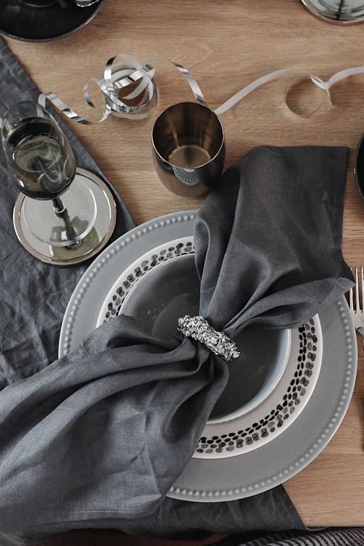 Duka till nyår i kalla toner av grått för en dukning i silver. Här ser du Byon servettring tillsammans med Dots porslin från Scandi Living.