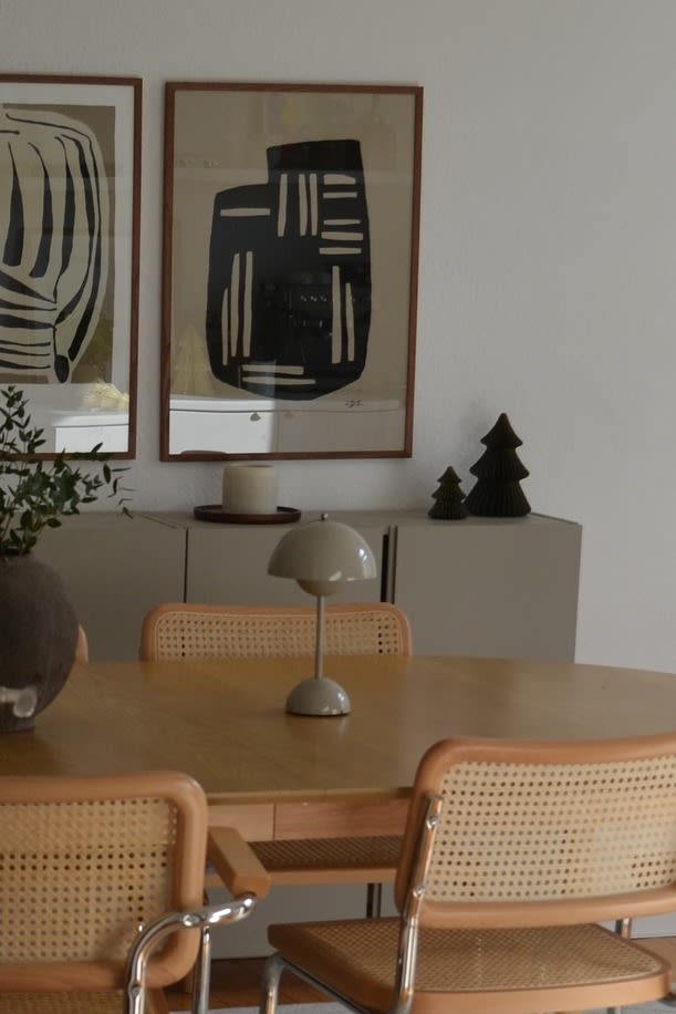 Greige är på väg tillbaka i färgtrenderna för 2025, här ser du den sladdlösa lampan Flowerpot VP9 från &Tradition på ett matbord i trä. 