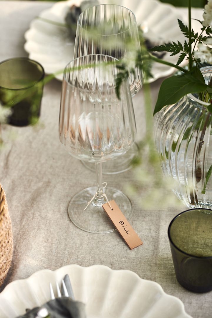 En sommardukning i trädgården är inte komplett utan fina placeringskort. Knyt placeringskorten med ett rustikt snöre runt Lifestyle rödvinsglas från Spiegelau.