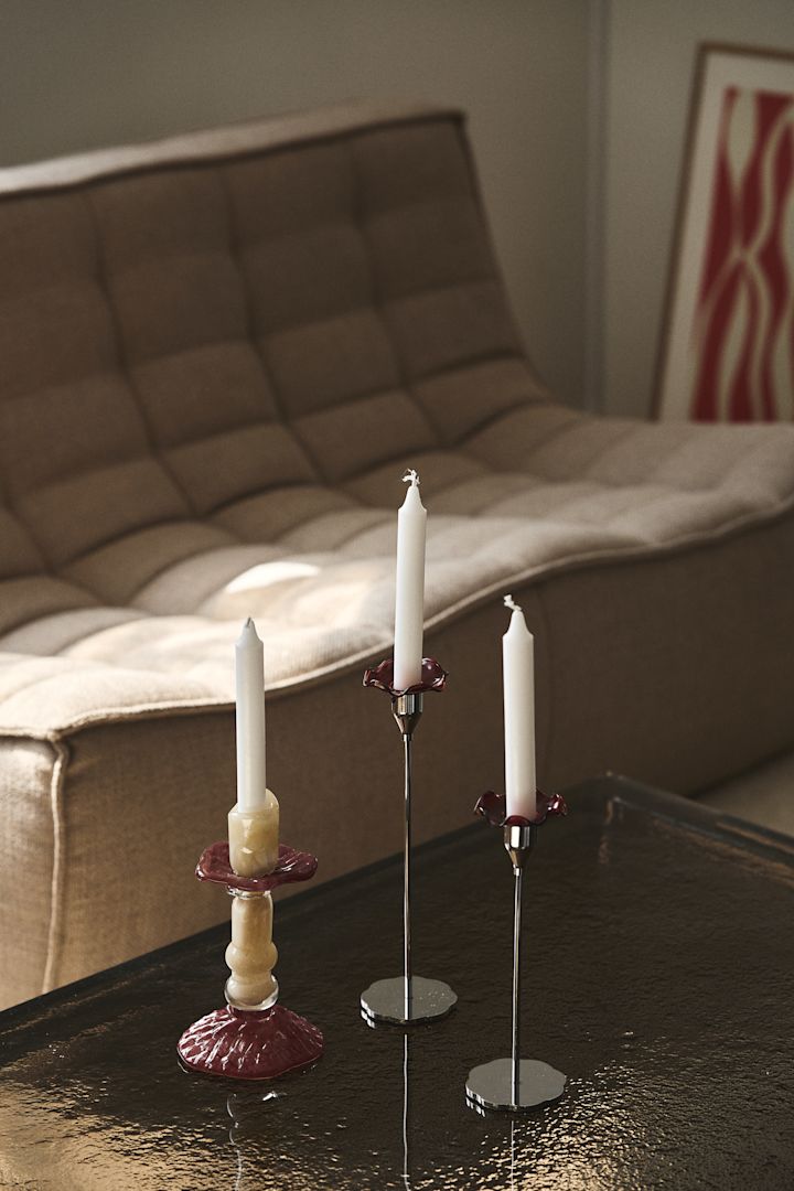Lara ljusstake från Byon, här på soffbord med glasskiva är tillverkad i färgat glas i beige och vinrött, designen är inspirerad av romerska kolonner.